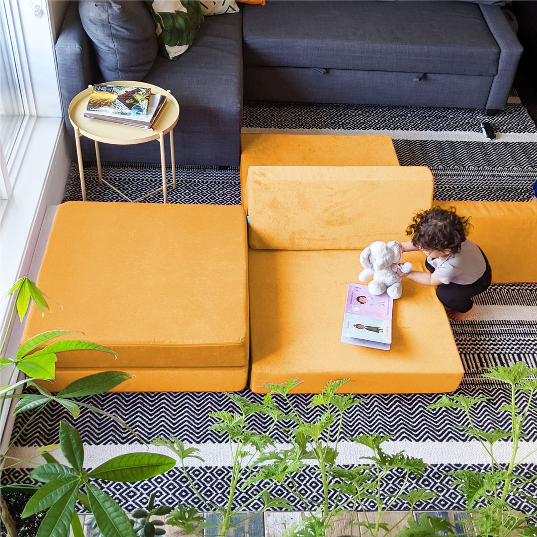 Baby playing on an orange modular play couch