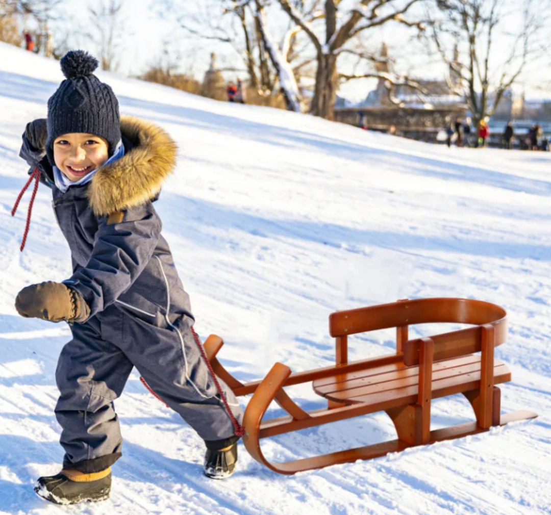 Kid Playing in the Snow with a Sled